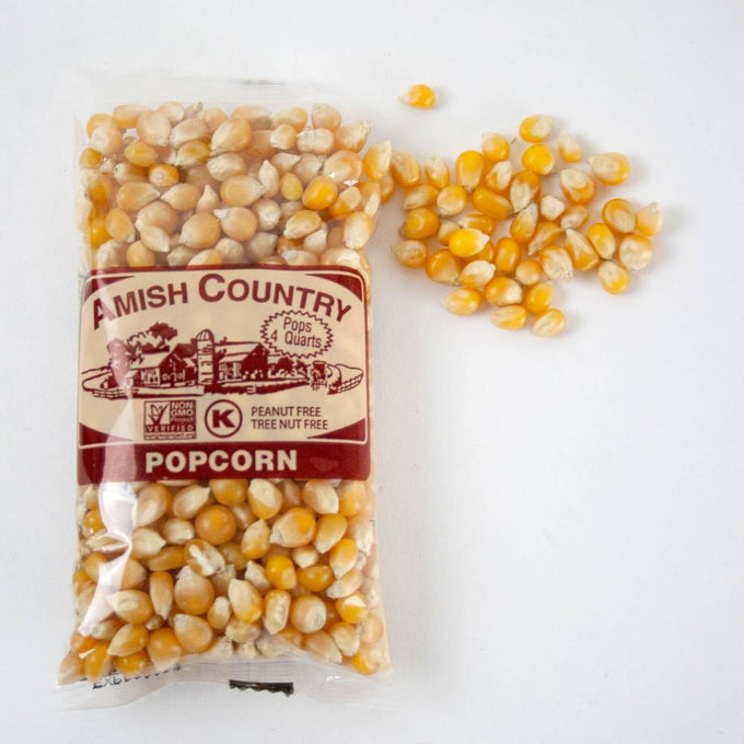 Clear bag of handcrafted Amish Country popcorn kernels in a light yellow shade with a few kernels spilled nearby, featured in Kitchen & Food, Snacks and Sweets, Popcorn, and USA Made collections.