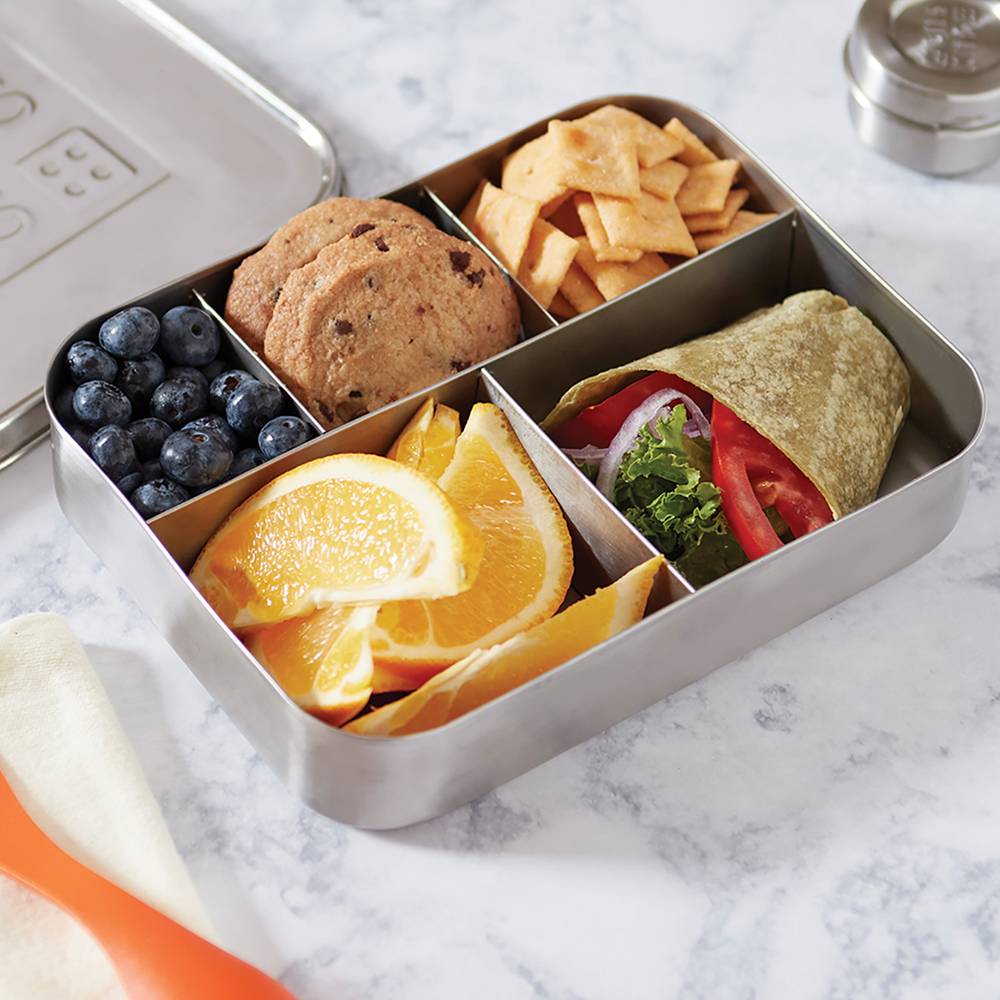 Stainless steel snack container with five compartments holding blueberries, chocolate chip cookies, cheese crackers, orange slices, and a vegetable wrap, featured in Kitchen & Food, Storage and Serving, Best Sellers, and Promo Eligible collections.