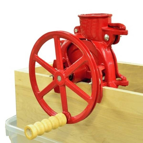 Handcrafted cast iron corn sheller in bright red with a 10-inch flywheel and wooden handle, clamped to a wood surface, featured in Farm, Garden & Tool, Farm Tools, Best Sellers, and Promo Eligible collections.