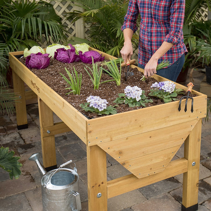 Elevated wooden garden bed filled with soil and growing assorted vegetables and flowers, designed to save space and reduce bending, featured in Farm, Garden & Tool collections.