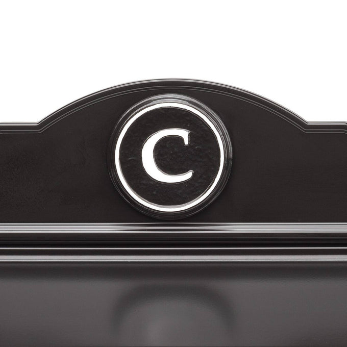 Close-up of a handcrafted black and white custom wall mount mailbox featuring a raised circular monogram letter "C," designed to enhance curb appeal in Home & Decor and USA Made collections.