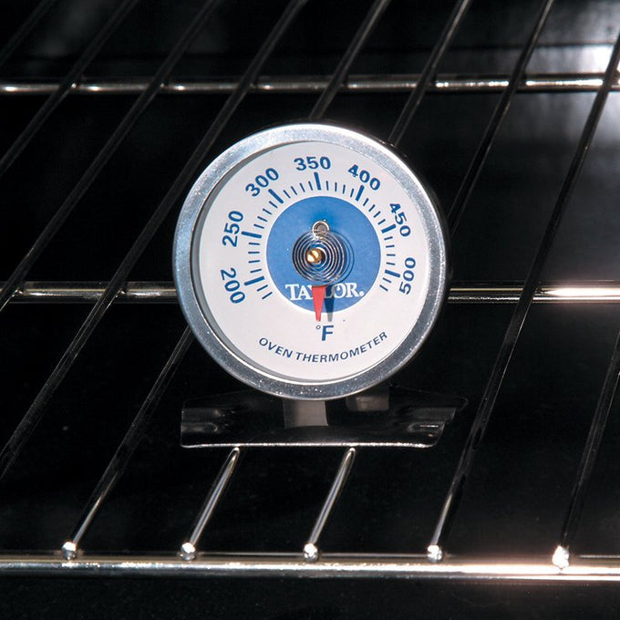 Aluminum oven thermometer with clear temperature dial in Fahrenheit, designed to hang or stand upright, ideal for monitoring heat in kitchen, stoves, cookware, and baking supplies collections.