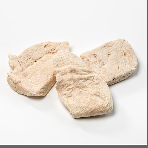 Three pale, textured, uncooked freeze-dried chicken breasts displayed on a white background, highlighting long-lasting food ideal for emergency supplies and kitchen collections.