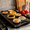 Pre-seasoned cast iron griddle with ribs on one side and flat surface on the other, cooking eggs and English muffins, ideal for Kitchen & Food, Cast Iron, USA Made, and Best Sellers collections.