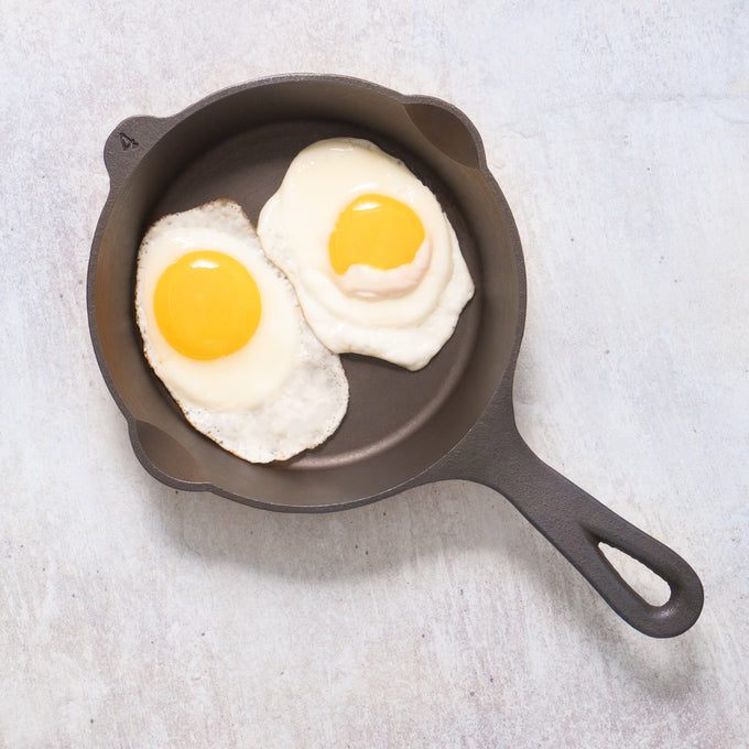 Handcrafted 7-inch cast iron skillet made in the USA cooking two sunny-side-up eggs, featured in Farm, Garden & Tool, Kitchen & Food, Camping, Cast Iron, and Best Sellers collections.