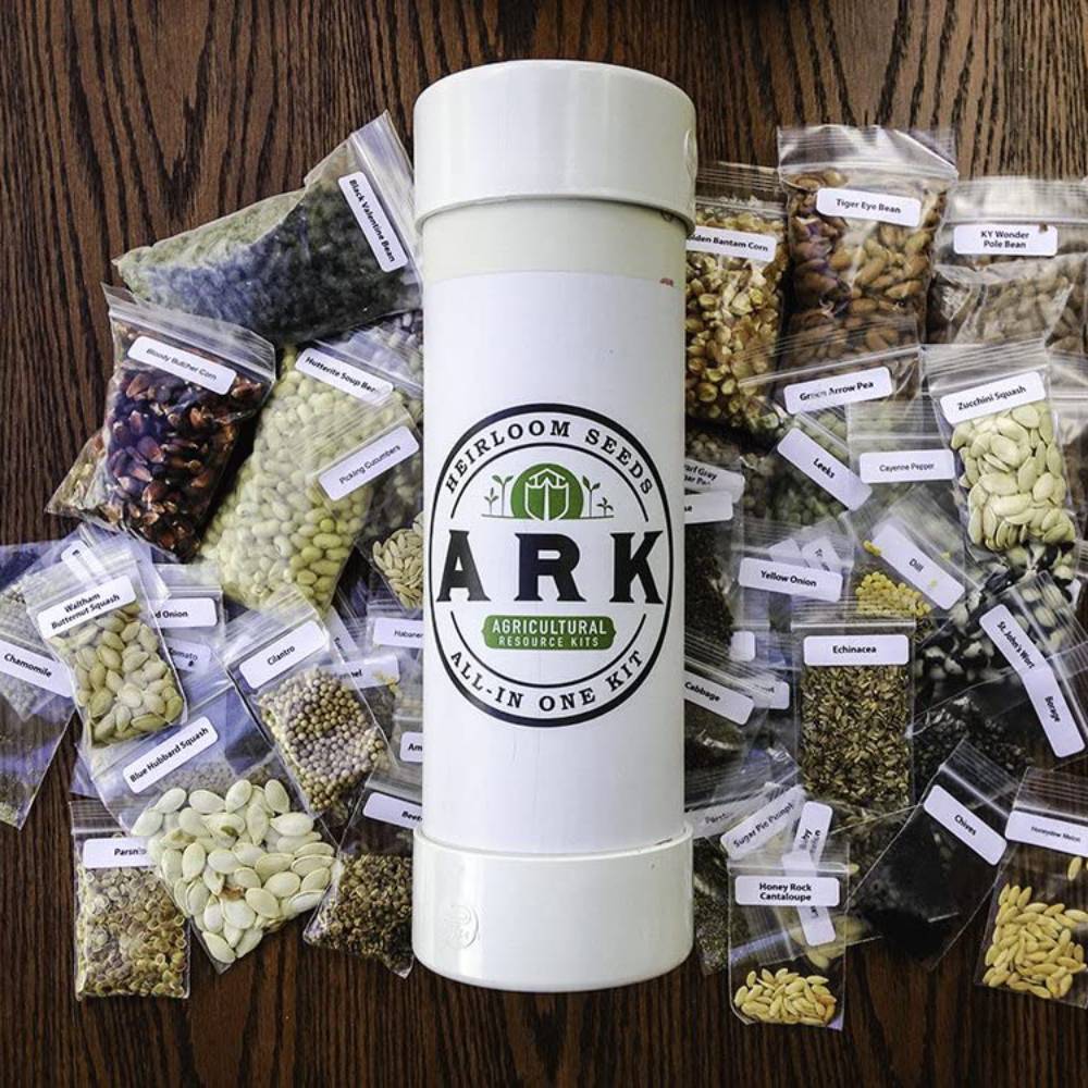 Tall white cylindrical container labeled ARK All-in-One Heirloom Seeds Kit surrounded by multiple clear plastic bags of various organic seeds, ideal for farm, garden & tool, and seeds and planting collections made in USA
