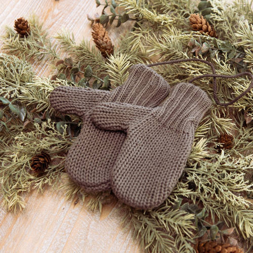 Cozy gray cotton blend mittens joined by a durable string, resting on dried pine and cedar branches with pinecones, ideal for Home & Decor and Holiday Decor collections.