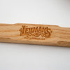 Close-up of a wooden handle engraved with Lehman’s logo and tagline, showcasing handcrafted quality for tools in farm, garden, and wood cutting collections.
