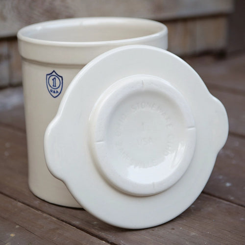 Cream-colored handcrafted stoneware crock cover with side handles, made in USA, designed for kitchen food preservation, fermenting, and pickling collections.