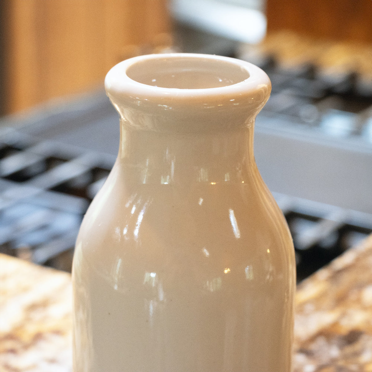 Handcrafted ceramic stoneware milk bottle in creamy white, made in the USA, ideal for kitchen use, home decor, storage and serving, featured in Best Sellers and Promo Eligible collections.