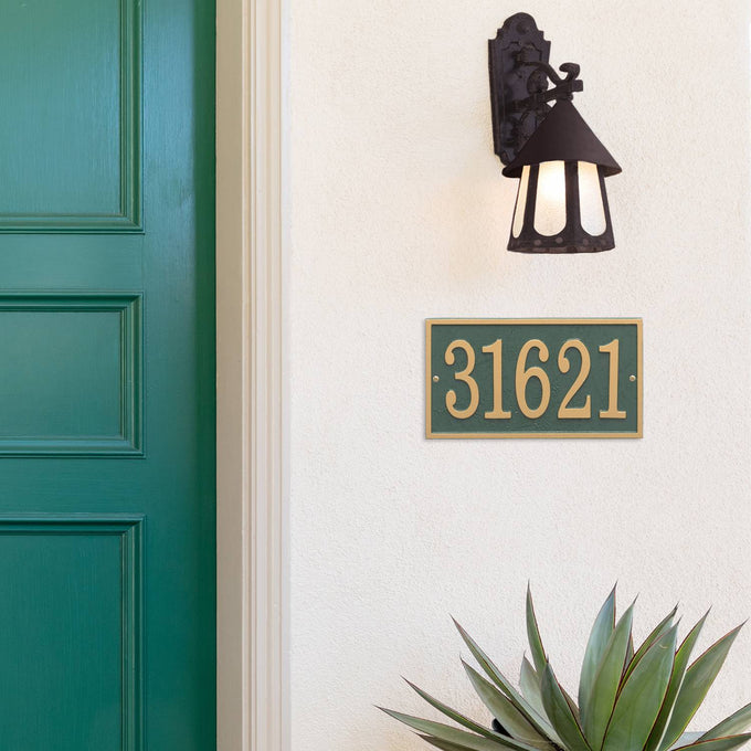 Green and gold rectangular custom address plaque displaying house number 31621 mounted on white exterior wall beneath a rustic black lantern light, near green front door, handcrafted in the USA, suitable for Home & Decor, Household Helpers, Mailboxes and Address Signs, and Best Sellers collections.