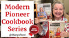 Smiling woman showcasing two handcrafted modern pioneer cookbooks with traditional recipes, featured in best sellers under Toys, Books & Games and Cookbooks collections.