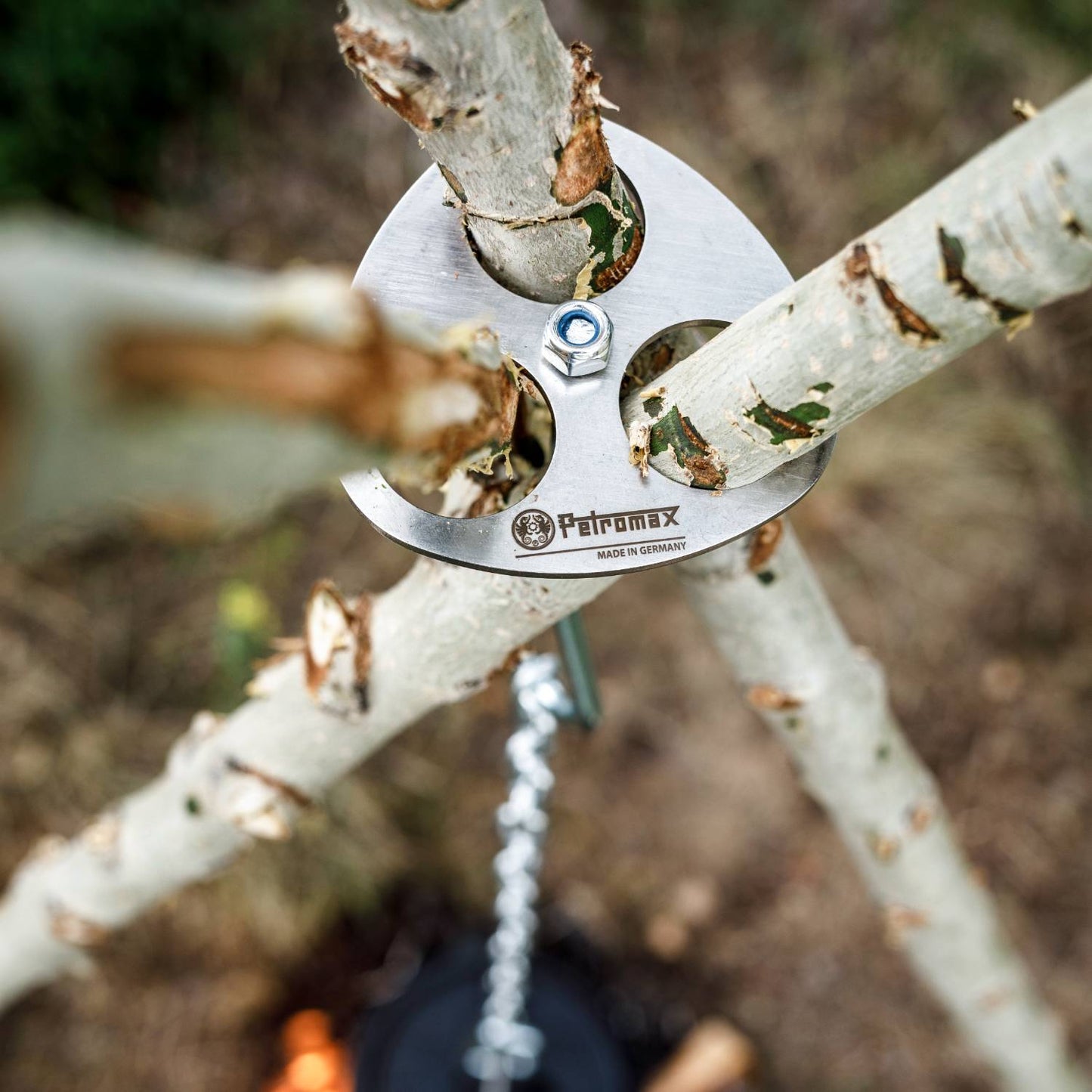 Stainless steel lashing disc secured with bolt and chain, fastening three natural branches to form a sturdy outdoor tripod, ideal for Farm, Garden & Tool, Camping, Best Sellers, and Promo Eligible collections.