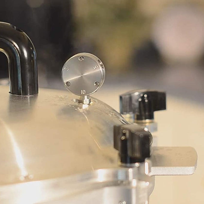 Close-up of a stainless steel pressure gauge and black control knobs on a handcrafted USA-made pressure canner, featured in Kitchen & Food, Food Preservation, and Pressure Canners collections.