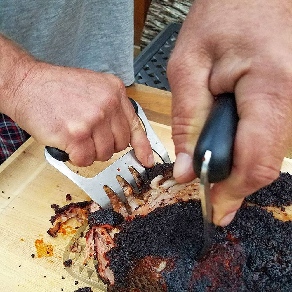 Set of two stainless steel meat shredding claws with black ergonomic handles, shown shredding smoked meat on a wooden cutting board, featured in Kitchen & Food and Kitchen Gadgets collections.