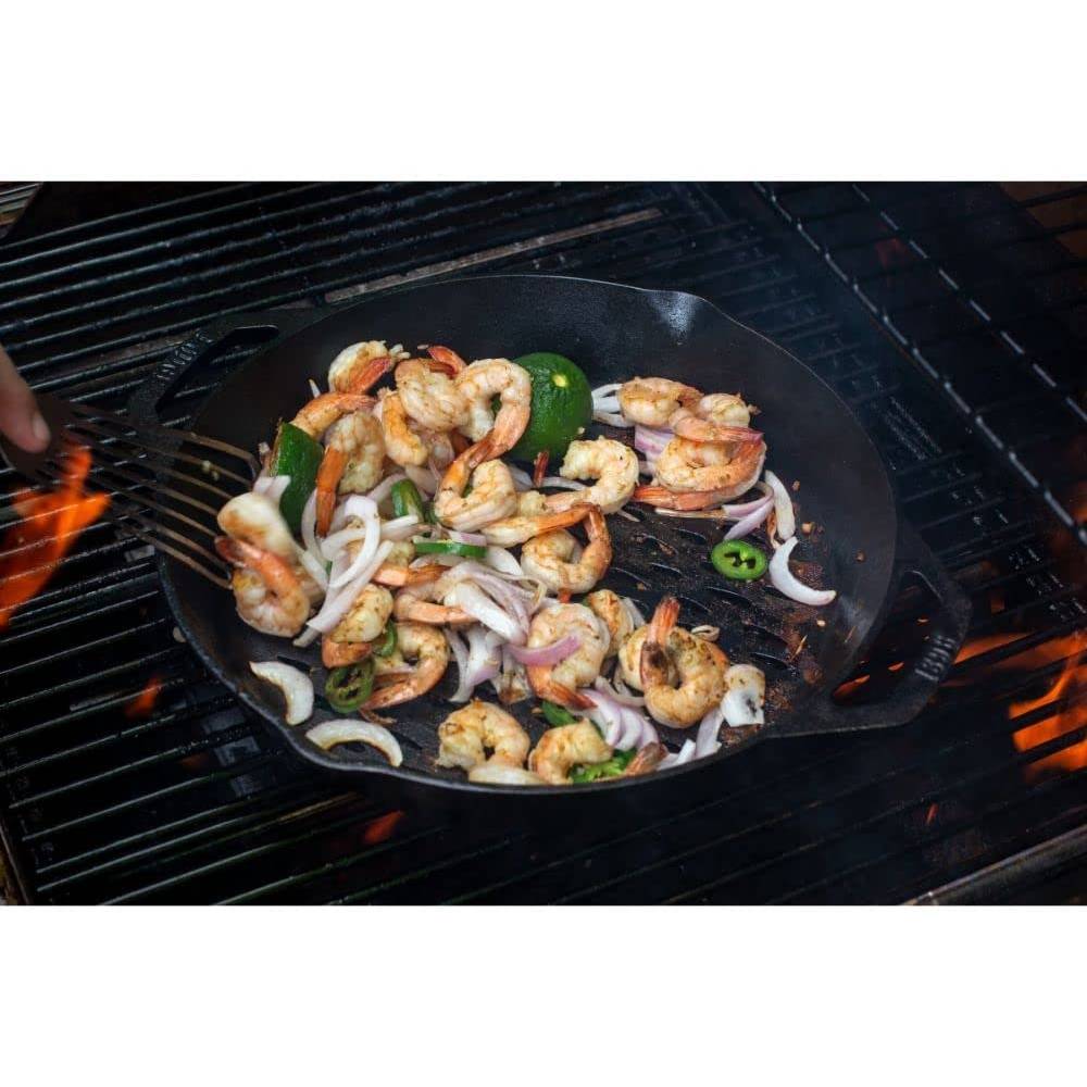 Handcrafted seasoned cast iron grill basket with dual handles cooking shrimp, sliced onions, green pepper, and zucchini over open flame, featured in Kitchen & Food, Cast Iron, Grilling, and Best Sellers collections.