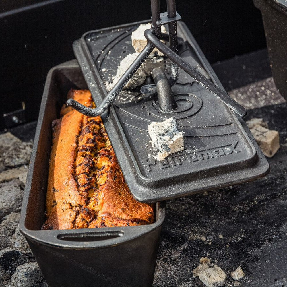 Handcrafted durable cast iron loaf pan with lid cooking a golden-brown loaf over hot coals, perfect for Farm, Garden & Tool, Kitchen & Food, Camping, Cookware, Cast Iron, and Bread Making Supplies collections.