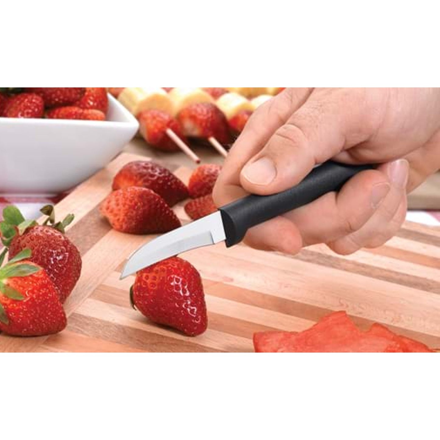 Handcrafted Rada Granny Parer featuring a hand-sharpened high carbon surgical stainless steel blade and solid black handle slicing fresh strawberries, made in USA, ideal for Kitchen & Food and Farm, Garden & Tool collections.
