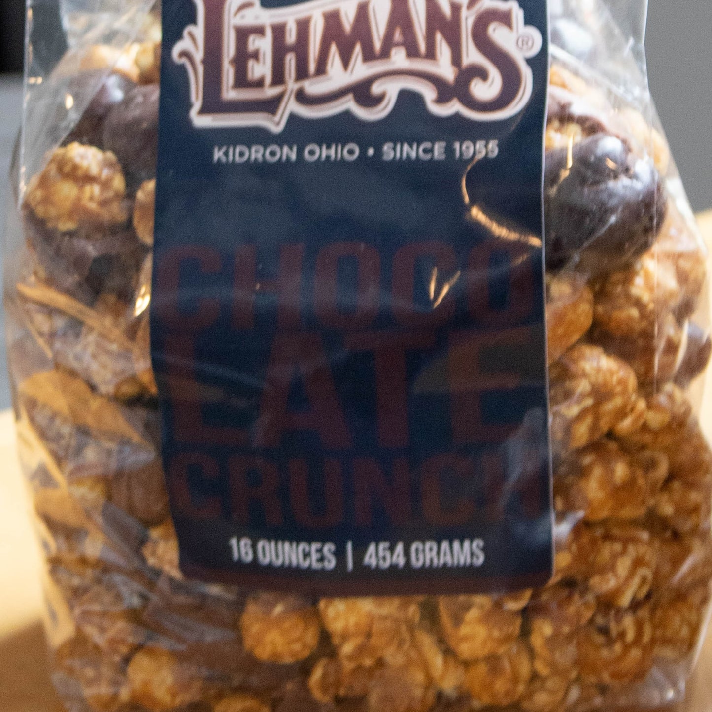 Clear bag of handcrafted caramel popcorn crunch with chocolate coating, an exclusive sweet and crunchy snack made in USA, featured in Kitchen & Food, Snacks and Sweets, Popcorn, USA Made, and Best Sellers collections.