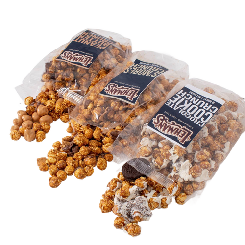 Three clear bags of handcrafted caramel popcorn crunch in different flavors with mix-ins like cookies and peanut butter bites, a unique snack made in USA, perfect for Kitchen & Food, Snacks and Sweets, Popcorn, USA Made, and Best Sellers collections.