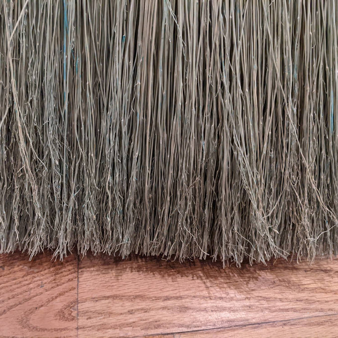 Close-up view of tightly hand-bound natural corn straw bristles on a large Amish made broom, ideal for farmhouse and household cleaning tasks, crafted in the USA.