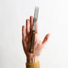 Handheld old-fashioned kitchen fork with three stainless steel tines and a brass-riveted dark brown hardwood handle, handcrafted in USA, ideal for cooking and grilling tasks.