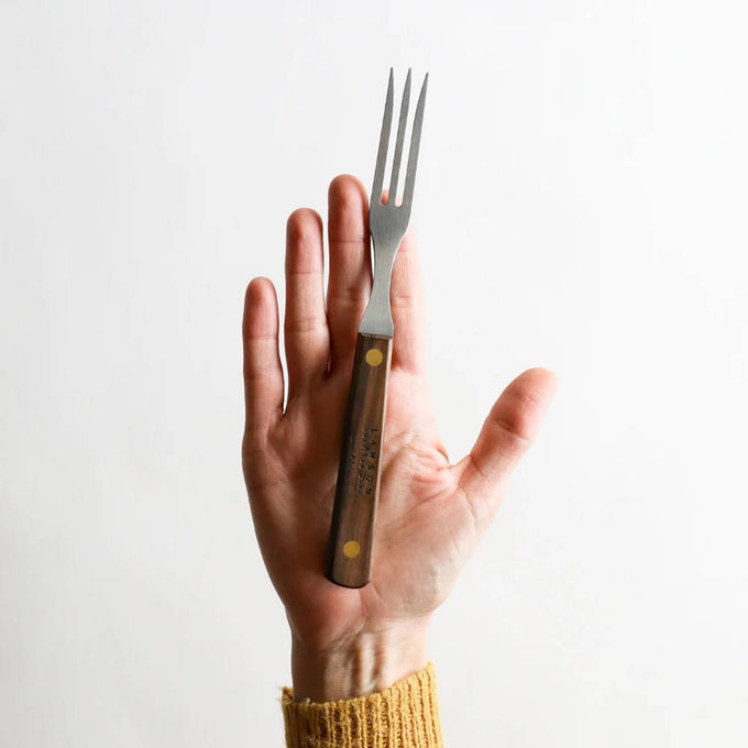 Handheld old-fashioned kitchen fork with three stainless steel tines and a brass-riveted dark brown hardwood handle, handcrafted in USA, ideal for cooking and grilling tasks.