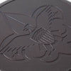 Close-up of cast iron skillet surface featuring embossed Boy Scout emblem with eagle, shield, and fleur-de-lis design, highlighting durable seasoning and USA craftsmanship.
