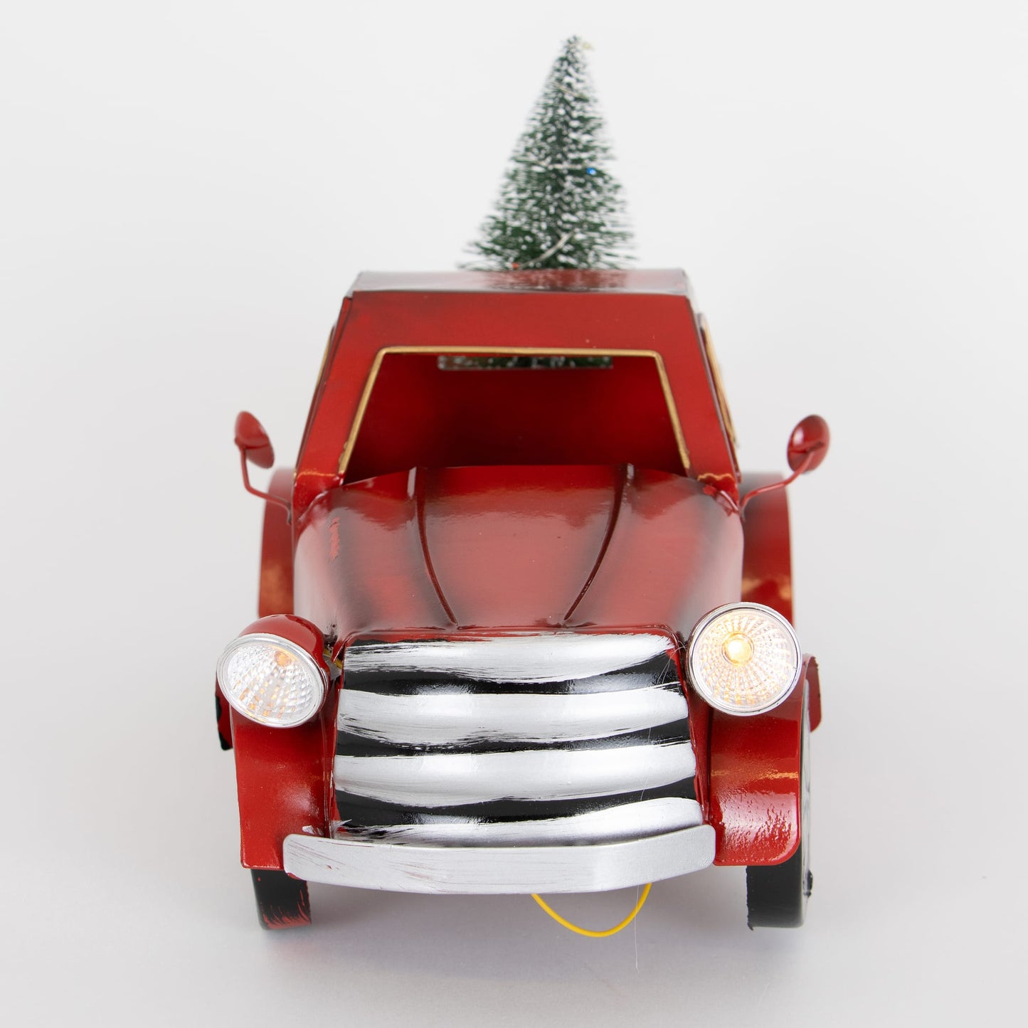 Handcrafted red metal holiday truck with illuminated headlights carrying a small frosted green tree, perfect for Home & Decor, Holiday Decor, and Best Sellers collections.
