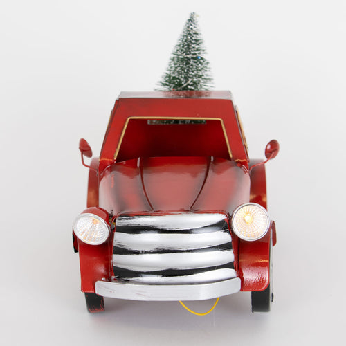 Handcrafted red metal holiday truck with illuminated headlights carrying a small frosted green tree, perfect for Home & Decor, Holiday Decor, and Best Sellers collections.