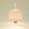 Handcrafted clear glass oil lamp with warm bright light, featuring a white parchment shade and tripod, ideal for farm, garden, emergency supplies, and table lighting collections.