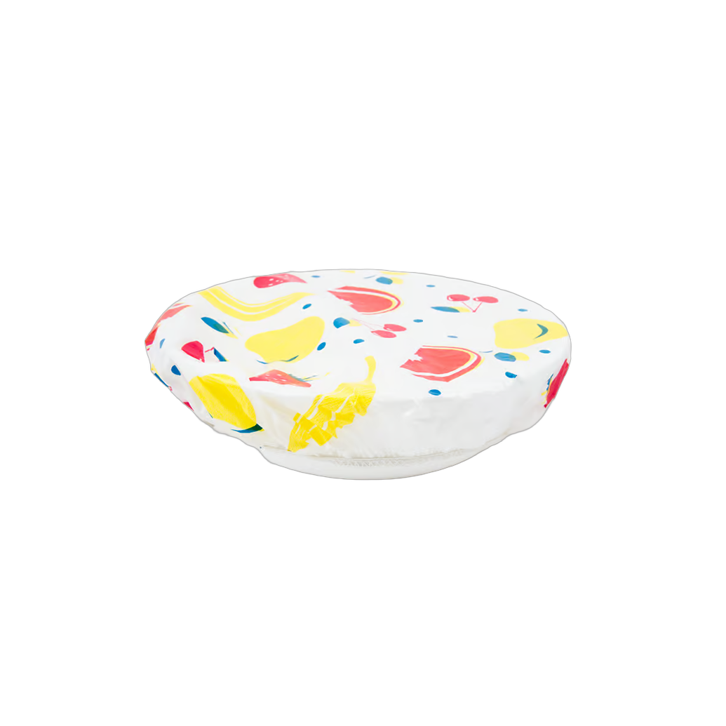 Colorful reusable bowl cover with elastic band securing a fruit-patterned plastic cover over a glass bowl, featured in Kitchen & Food, Storage and Serving, and Best Sellers collections.