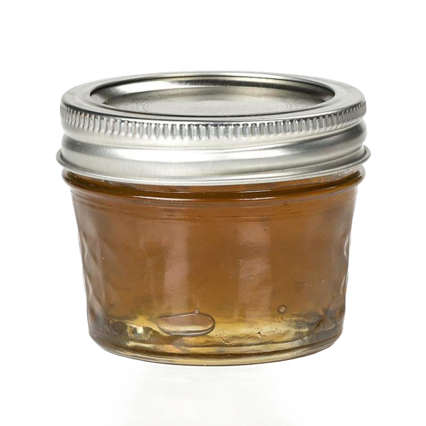 Clear regular-mouth glass jelly jar with quilted texture and silver metal lid, filled with honey-colored preserve, ideal for food preservation and canning, made in USA.