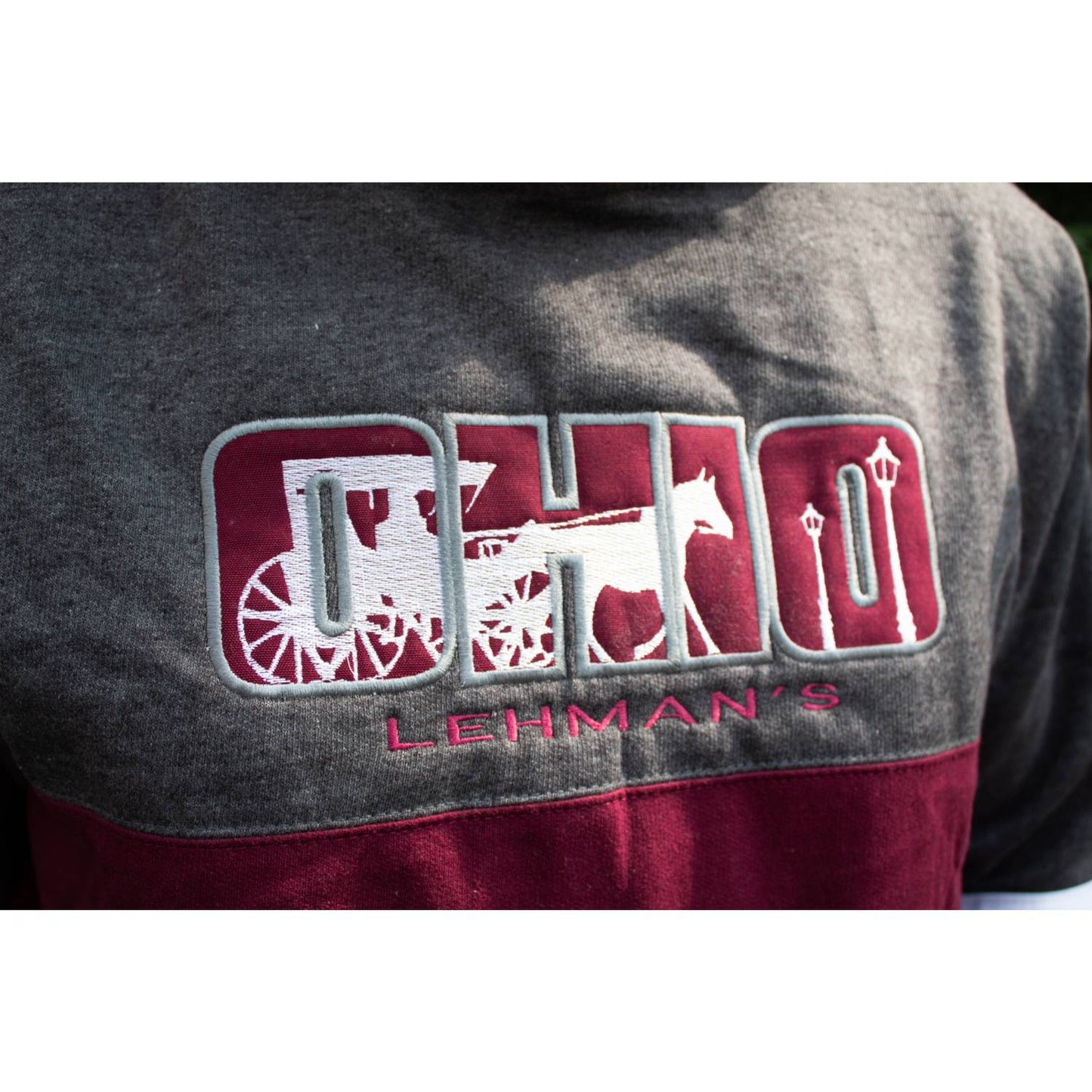 Close-up of handcrafted fleece hoodie sweatshirt with embroidered Ohio design featuring a horse and carriage in burgundy and gray, part of Health & Wellness and Best Sellers collections.