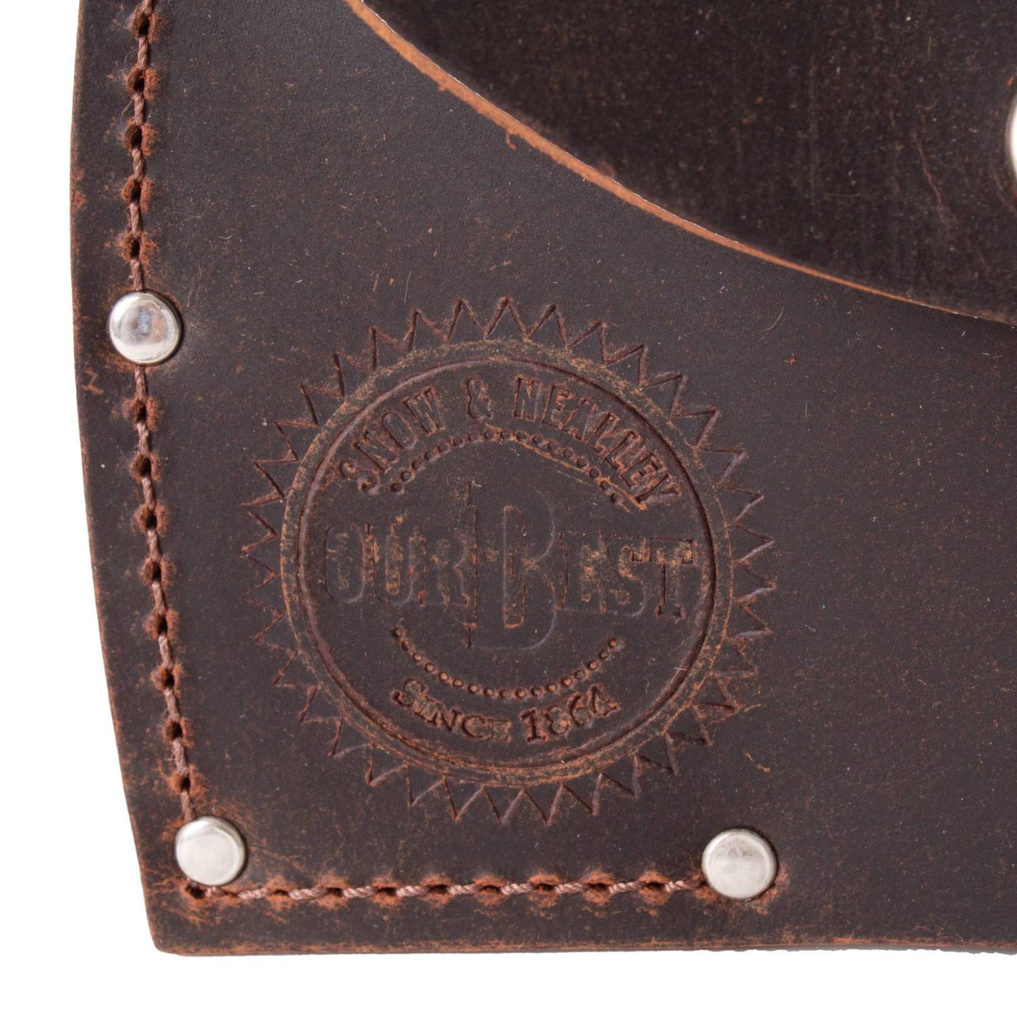 Close-up of stamped logo on dark full-grain leather sheath with reinforced stitching and metal rivets, handmade in USA, Amish made, ideal for Farm, Garden & Tool and Knives & Axes collections.