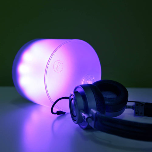 Handcrafted inflatable LED solar light glowing in a calming purple shade beside a pair of black headphones, ideal for eco-friendly Camping, Farm, Garden & Tool, and Lamps & Lighting collections.
