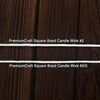 Close-up of two white square braided candle wicks laid horizontally on a dark wooden surface, suitable for use in candle making and included in lamps and lighting collections.