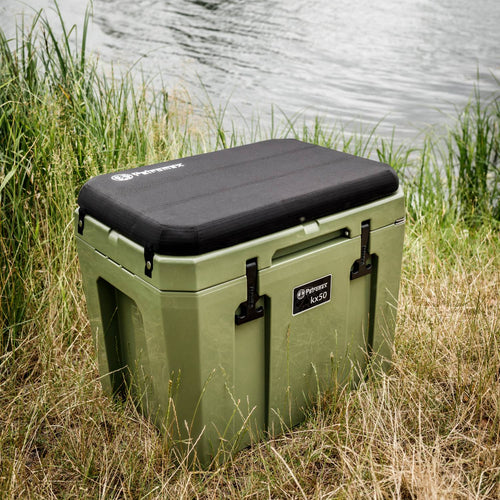 Olive green cooler with black cushioned lid and sturdy latches, set on grassy bank beside a calm lake, designed for reliable outdoor use in Farm, Garden & Tool, Camping, and Best Sellers collections.