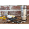 Adjustable measuring set with stainless steel and black handles, including scoop, tablespoon, teaspoon, and 2-cup cup, shown on wooden surface with baking ingredients, ideal for Kitchen & Food and Baking Helpers.