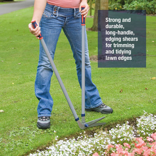 Person using long-handled edging shears with durable tubular steel handles and sharp blades to trim and tidy lawn edges near flowerbeds, ideal for Farm, Garden & Tool and Lawncare collections.