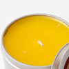 Hand-poured yellow citronella candle in a compact metal tin, handcrafted for outdoor use, ideal for camping, pest control, and garden lighting collections.