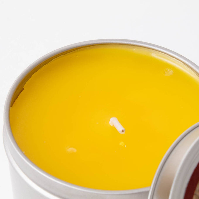 Hand-poured yellow citronella candle in a compact metal tin, handcrafted for outdoor use, ideal for camping, pest control, and garden lighting collections.