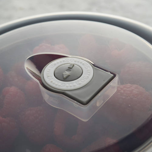 Close-up of a translucent airtight lid with vent dial on a cream-colored all-purpose bowl containing fresh raspberries, ideal for Kitchen & Food, Cookware, Baking Supplies, Storage and Serving, Best Sellers, and Promo Eligible collections.