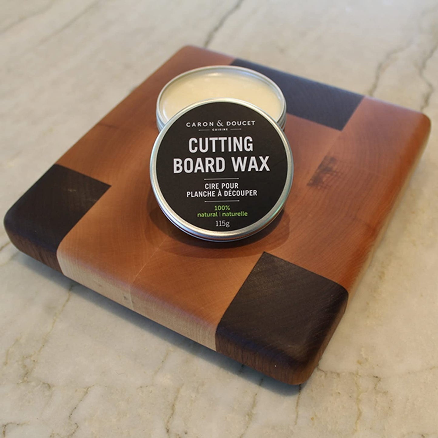 Round tin of plant-based cutting board wax on a wooden cutting board with dark corner accents, featured in Kitchen & Food, Food Prep, and Best Sellers collections.
