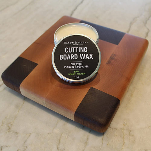 Round tin of plant-based cutting board wax on a wooden cutting board with dark corner accents, featured in Kitchen & Food, Food Prep, and Best Sellers collections.