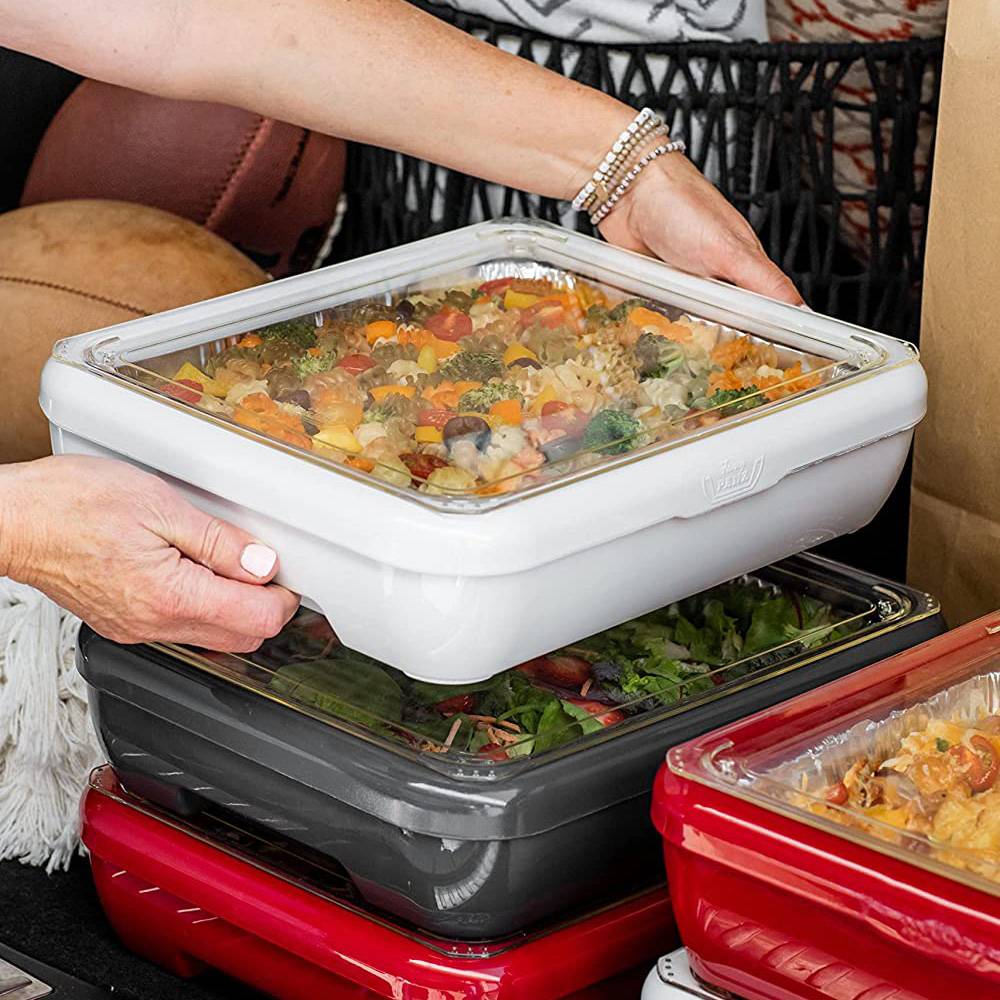 Person lifting a white Fancy Panz foil pan cover with a clear removable window over stacked black and red foil pans, showcasing sturdy food transport solution for Kitchen & Food and Storage collections, made in USA.