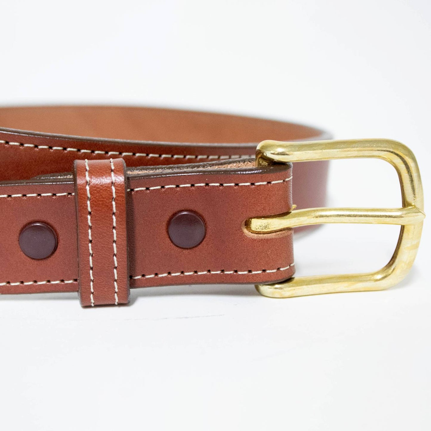 Close-up of a handcrafted rich brown leather belt with detailed white stitching and a sturdy polished brass buckle, made in USA, Amish Made, featured in Clothing and Accessories collections.