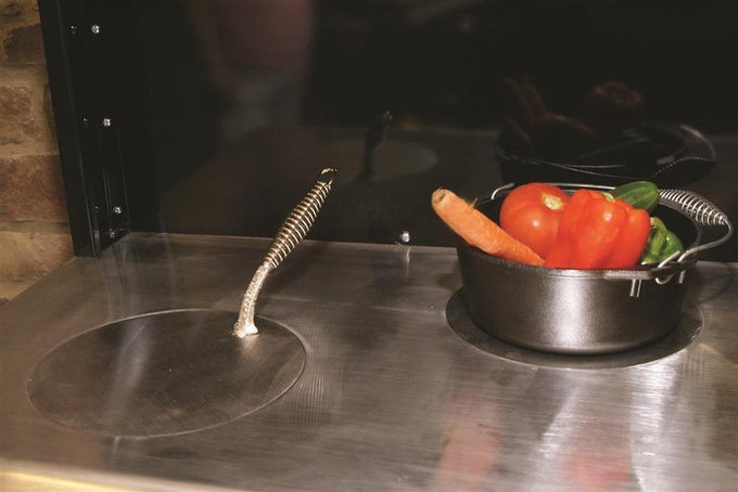 Close-up of a stainless steel cooktop on a handcrafted wood cookstove featuring a lifted round cover and a cast iron pot filled with fresh vegetables, ideal for Stoves, Cookstoves, Best Sellers, and All Stoves & Appliances collections.