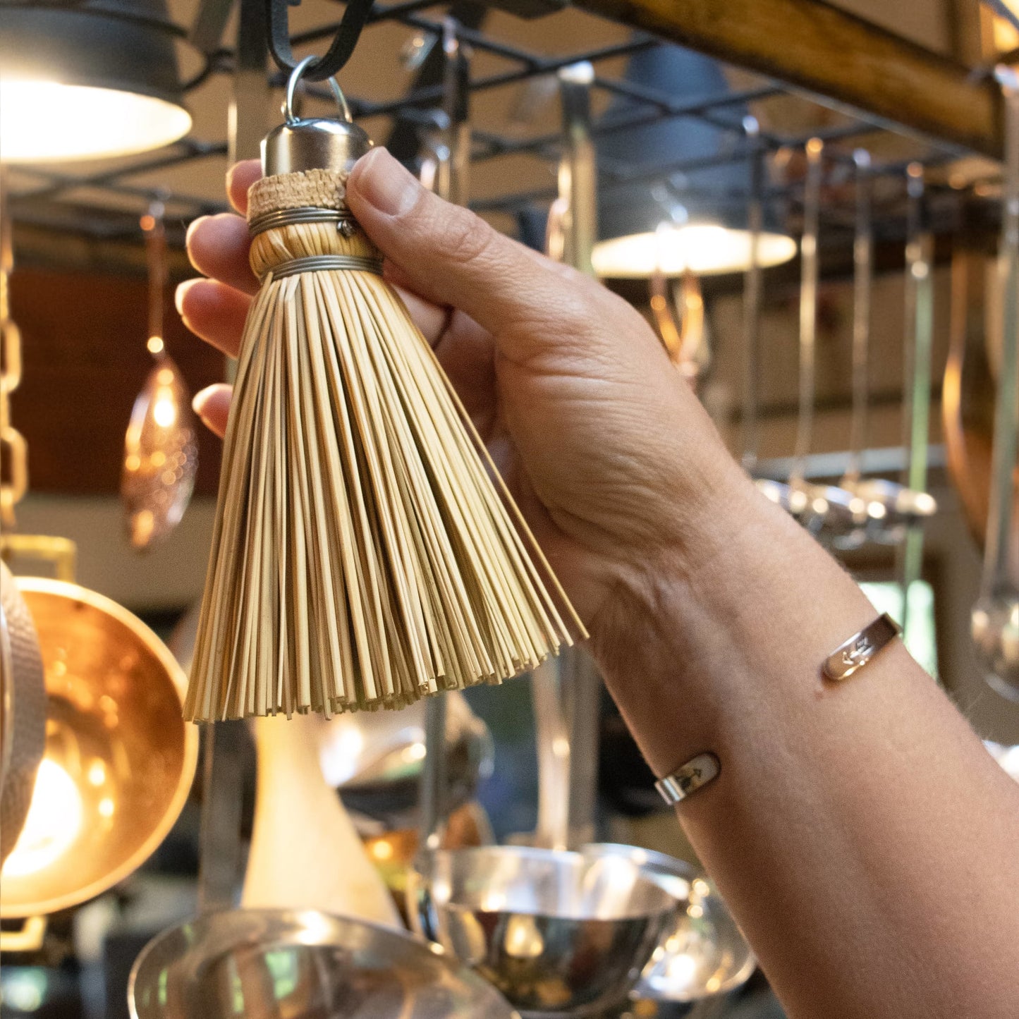 Handcrafted Amish-made miniature straw broom with metal loop for hanging, held in kitchen setting, featured in Kitchen & Food, Cleaning Utensils, and USA Made collections.