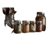 Collection of glass storage jars filled with dried herbs and spices, labeled and sealed with metal lids, displayed with vintage metal kitchen utensils, ideal for Home & Decor and Kitchen & Food collections.